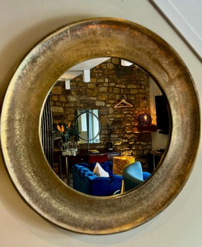 a circular mirror reflecting a living room with blue chairs at Quite Simply French in Lancaster