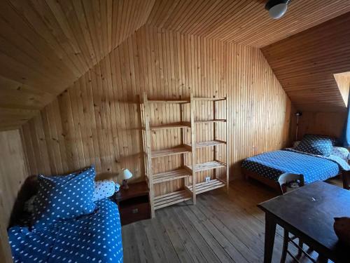 a room with two beds and a wooden wall at Maison dans la prairie in Plurien