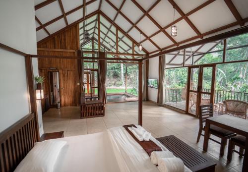 Coffee and Pepper Plantation Homestay في تيكادي: غرفة نوم مع سرير في غرفة مع نوافذ