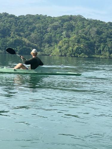 a man sitting on a kayak in the water at Jungle Container Escape in Golfito