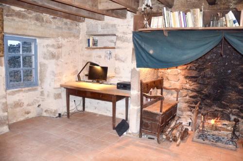 Habitación de piedra con escritorio y ordenador. en Maison d'une chambre avec jardin amenage et wifi a Meyrignac l'Eglise a 3 km de la plage en Meyrignac-lʼÉglise
