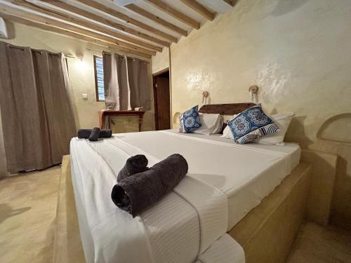una camera da letto con un grande letto bianco con asciugamani di Bahari Beach Bungalows a Jambiani
