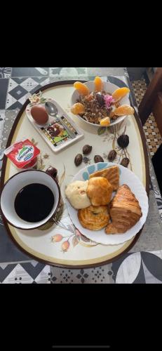 einen Tisch mit einem Frühstücksteller und Kaffee in der Unterkunft Chambre standard dans une maison in El Biar