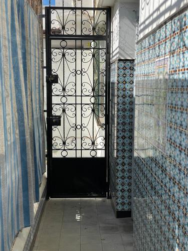 eine schwarze Tür in einem Zimmer mit Wandfliesen in der Unterkunft Chambre standard dans une maison in El Biar