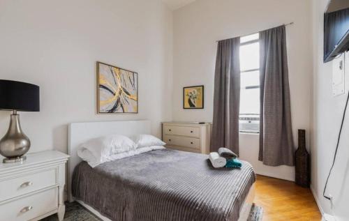 a bedroom with a bed and a dresser and a window at Majestic 3 Bedroom Apartment in NYC! in New York