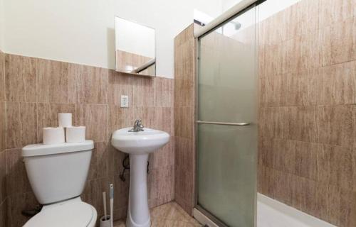 y baño con ducha, aseo y lavamanos. en Majestic 3 Bedroom Apartment in NYC! en Nueva York