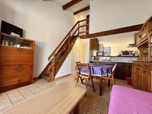 une cuisine et une salle à manger avec une table et un escalier dans l'établissement Jolie maison T3 proche du centre Narbonne plage, à Narbonne-Plage