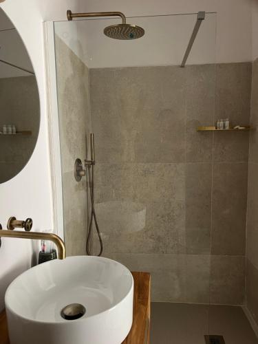 uma casa de banho com um lavatório branco e um chuveiro em Begani63 Boutique Apartments em Gaeta