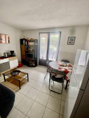 un salon avec une table et une cuisine dans l'établissement Appt T2 cabine RDC avec belle terrasse, à Saint Pierre La Mer