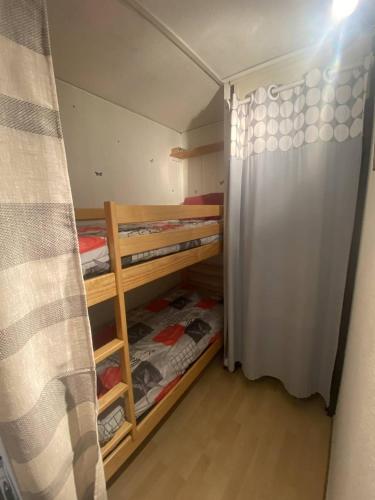 une petite chambre avec des lits superposés et un rideau dans l'établissement Appt T2 cabine RDC avec belle terrasse, à Saint Pierre La Mer