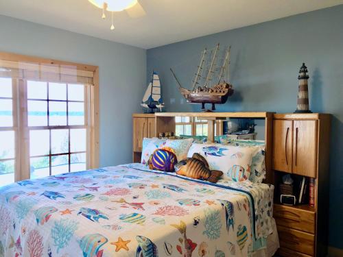 a bedroom with a large bed with aautical themed bedspread at The Torch Lake Bed and Breakfast in Central Lake