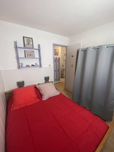 une chambre avec un lit rouge dans une pièce dans l'établissement Appt T2 cabine RDC avec belle terrasse, à Saint Pierre La Mer