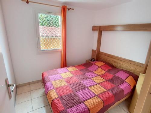 una camera da letto con un letto in una stanza con una finestra di Pavillon T2 avec grande terrasse a Narbonne-Plage