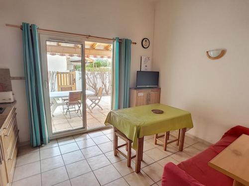 un soggiorno con tavolo, divano e patio di Pavillon T2 avec grande terrasse a Narbonne-Plage