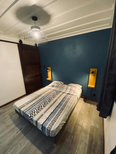 a bed in a room with a blue wall at LA VILLA ELISA in Cilaos