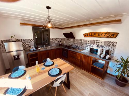 a large kitchen with a wooden table and chairs at LA VILLA ELISA in Cilaos