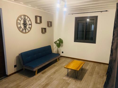 a living room with a blue couch and a clock at LA VILLA ELISA in Cilaos