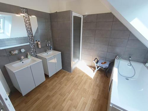 an attic bathroom with two sinks and a shower at B&B Bécherel in Bécherel