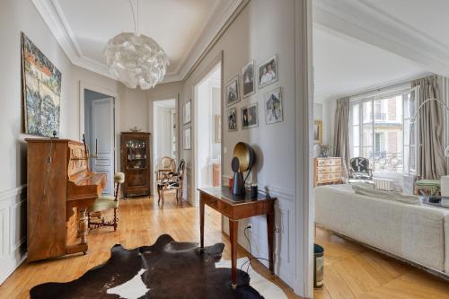 - un salon avec un canapé et un piano dans l'établissement Wonderful & large flat in the 7th - Eiffel Tower, à Paris