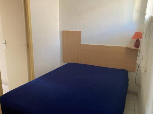 une chambre avec un lit avec une couverture bleue dans l'établissement Appt T2 à 300m de la plage, à Saint Pierre La Mer