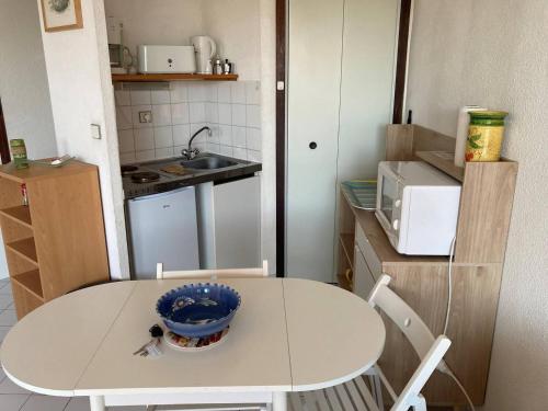 - une petite cuisine avec une table et un bol dans l'établissement Appt T2 à 300m de la plage, à Saint Pierre La Mer
