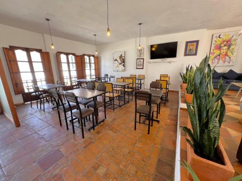 a dining room with tables and chairs and a tv at Hotel Antiguo Macondo in Villa de Leyva