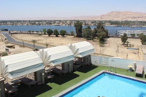 a hotel with a pool and a view of the water at اعلاني in Luxor