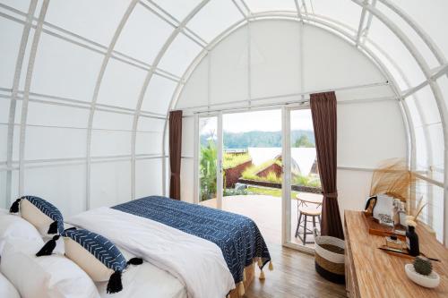 a bedroom with an arched ceiling with a bed and a window at The Dewi Kintamani Luxury Glamping and Natural Hotspring in Kintamani