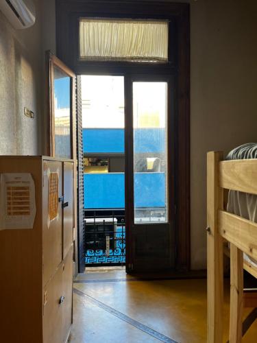 Parla Hostel في بوينس آيرس: غرفة مع باب مطلة على غرفة نوم