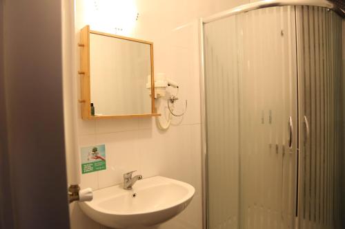 y baño con lavabo, espejo y ducha. en Maidos suites en Eceabat
