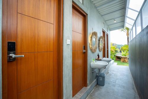 a bathroom with a door and a toilet and a sink at The Dewi Kintamani Luxury Glamping and Natural Hotspring in Kintamani
