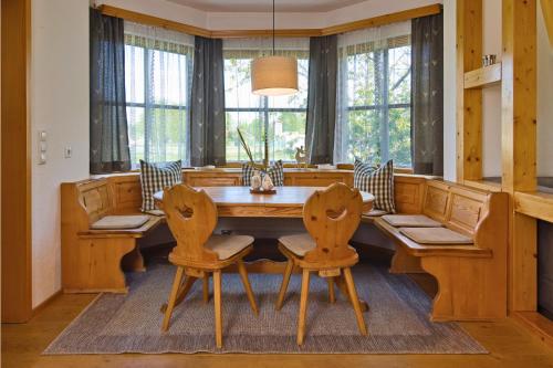 a dining room with a wooden table and chairs at Ferienhaus am Mühlbach Ammersee in Utting am Ammersee