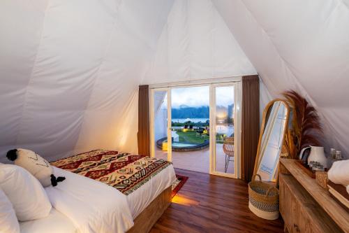 a bedroom with a bed and a view of a balcony at The Dewi Kintamani Luxury Glamping and Natural Hotspring in Kintamani