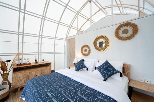 a bedroom with a large bed with blue and white sheets at The Dewi Kintamani Luxury Glamping and Natural Hotspring in Kintamani