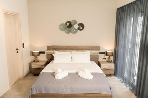 a bedroom with a large bed with towels on it at Lorien City Center Apartments in Ioannina