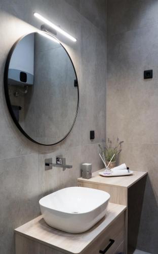 a bathroom with a large white sink and a mirror at Lorien City Center Apartments in Ioannina