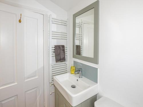 een witte badkamer met een wastafel en een spiegel bij 3 Bed in Whitstable WCC07 in Whitstable