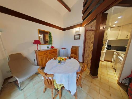 une cuisine avec une table et un chiffon de table blanc dans l'établissement Proche Mer - Appartement avec terrasse sans vis a vis, à Saint Pierre La Mer