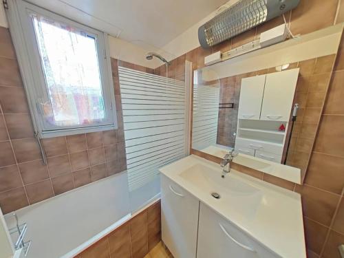 une salle de bain avec un lavabo, un miroir et une baignoire dans l'établissement Proche Mer - Appartement avec terrasse sans vis a vis, à Saint Pierre La Mer