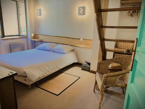 1 dormitorio con cama, escalera y silla en Le Domaine d'Arignac en Arignac