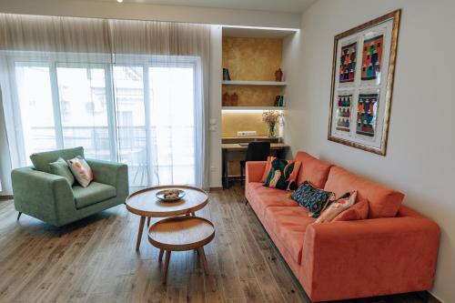 AnnaG apart في أثينا: غرفة معيشة مع أريكة برتقالية وطاولة