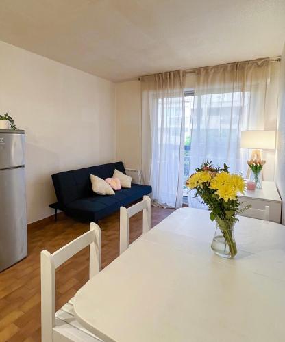 un salon avec une table et un canapé bleu dans l'établissement Charmant appartement à la plage, à Canet