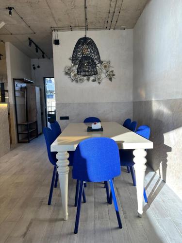 a white table with blue chairs in a room at Grigoleti Dream House in Grigoleti