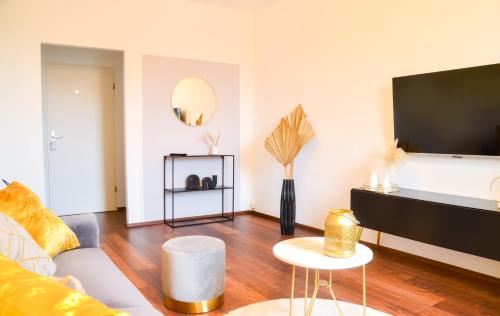 een woonkamer met een bank en een flatscreen-tv bij MILPAU Buer 3 - Modernes und zentrales Premium-Apartment mit Queensize-Bett, Netflix, Nespresso und Smart-TV in Gelsenkirchen
