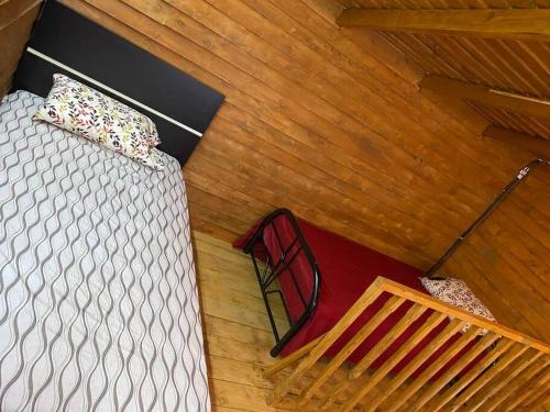 an overhead view of a bed in a room with wooden floors at Cabaña Aurora – COZY Cabin with an Amazing view! in San Pablo
