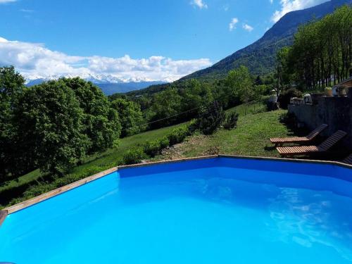 a swimming pool with a view of mountains at Coquette maison à la campagne in Apremont