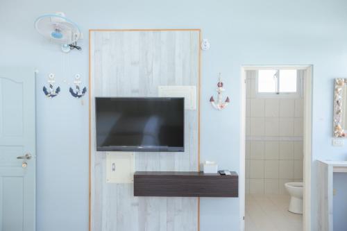 a bathroom with a flat screen tv on a wall at 綠島小巷 微光南寮館 in Green Island