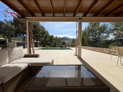 une terrasse avec un canapé, une table et une piscine dans l'établissement Villa Aldora. Villa con piscina en Moratalla, à Moratalla