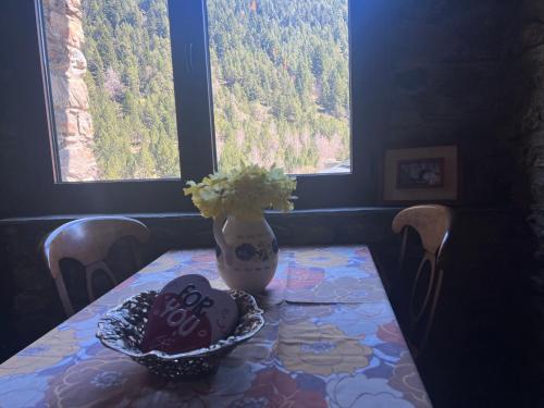a table with a vase on top of it with a vase at Borda Martí, Chalet de montaña en la Vall d'Incles HUT1-08422 in Canillo