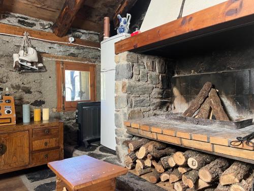 a room with a stone fireplace and a wooden table at Borda Martí, Chalet de montaña en la Vall d'Incles HUT1-08422 in Canillo